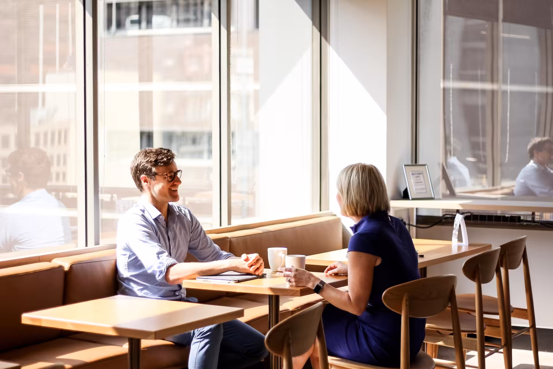 Two members talking over coffee in the coworking cafe at 456 Lonsdale Street, Melbourne