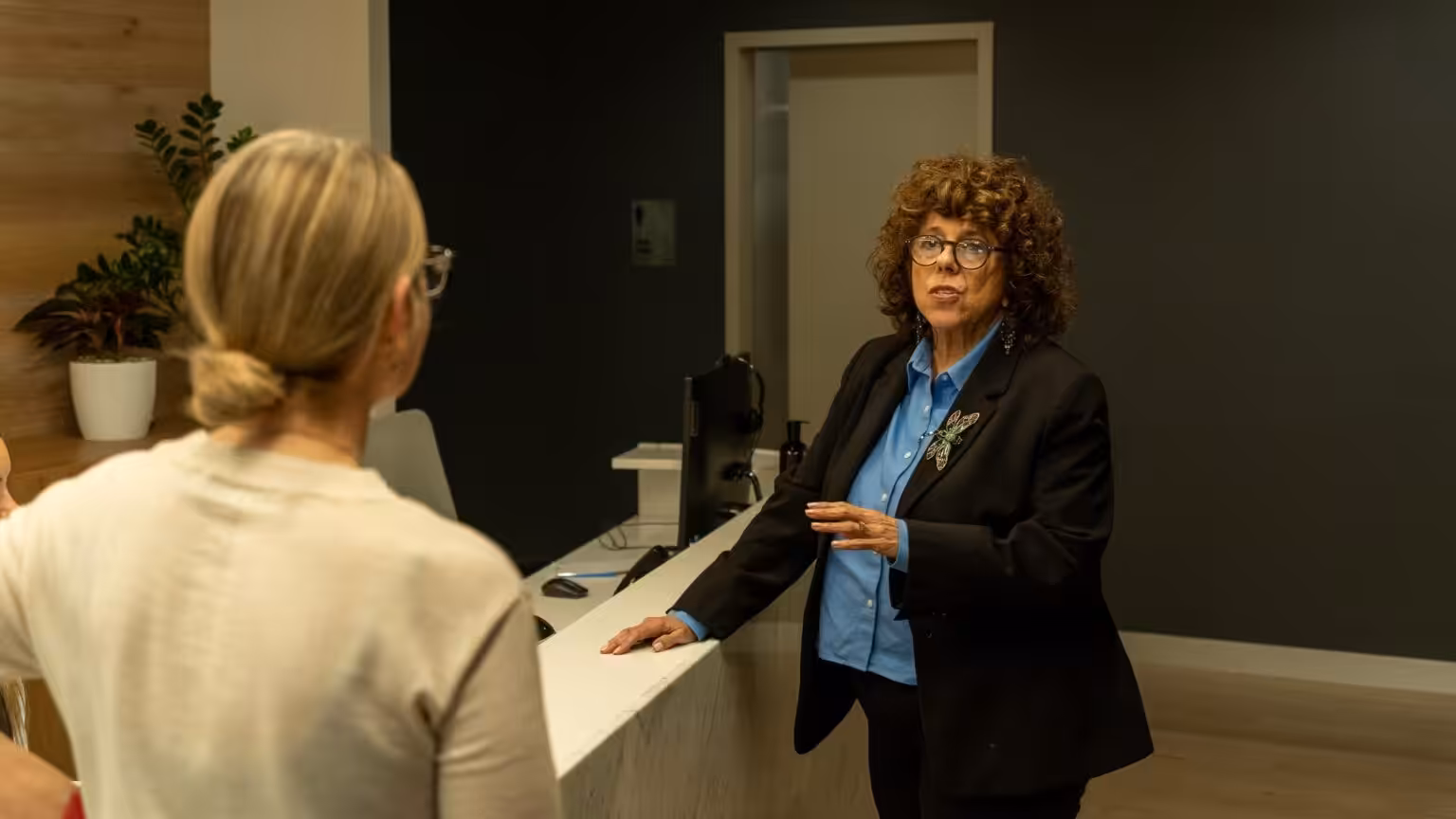 A member talking with the receptionist at the Clarence front desk
