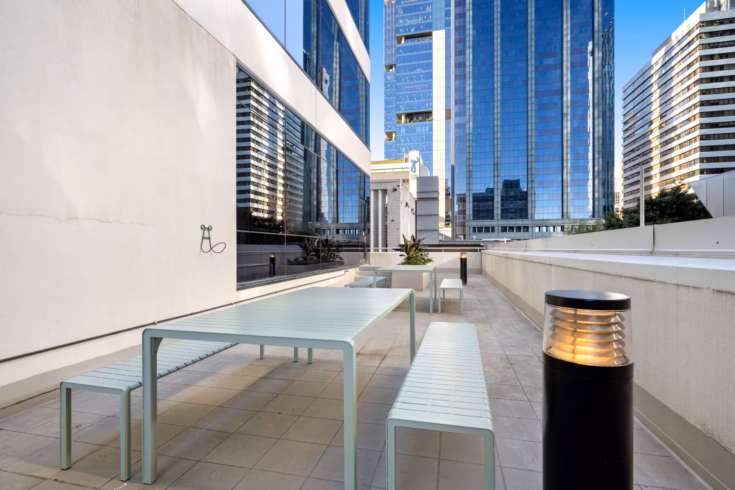 The outdoor terrace at 95 North Quay, Brisbane, with seating and the city towers behind